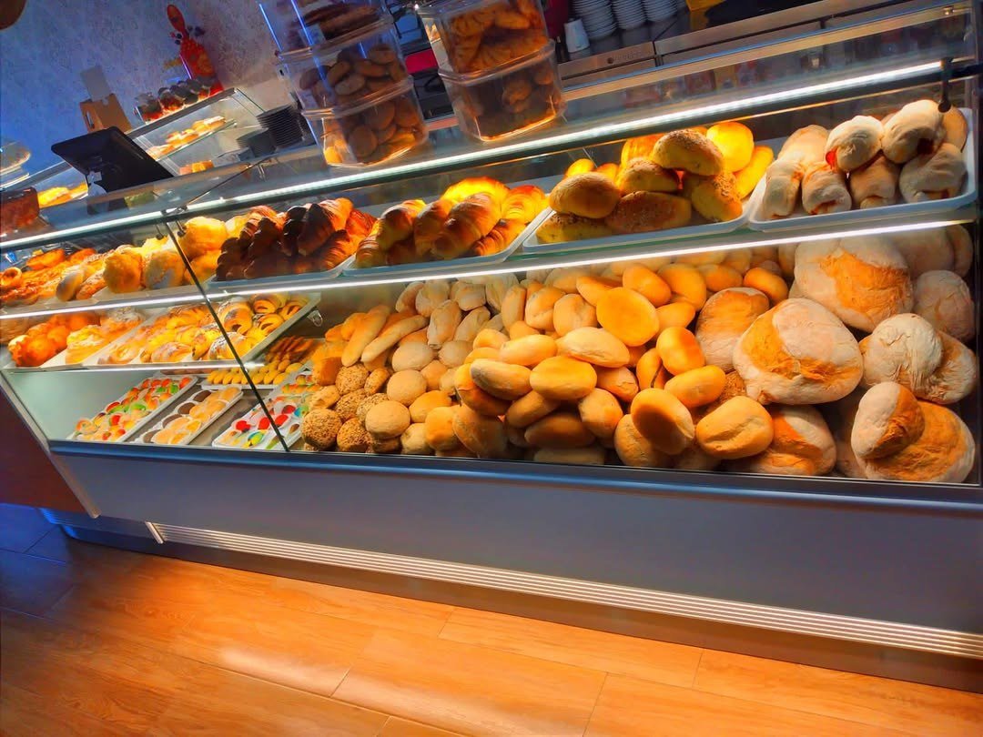 Vitrine iluminada com pães e broas de vários tamanhos